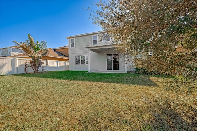 back of property with a patio area and a yard