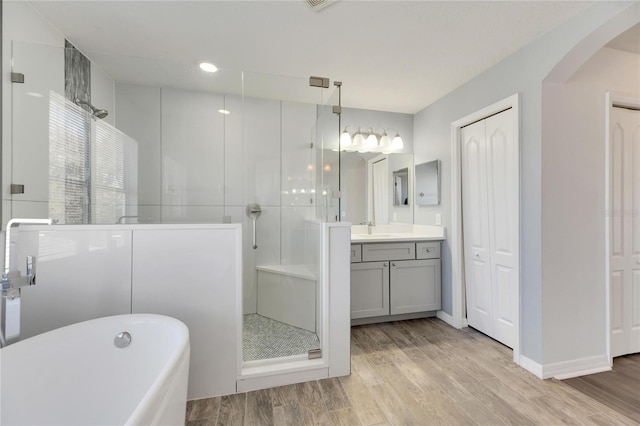 bathroom featuring hardwood / wood-style floors, vanity, and shower with separate bathtub