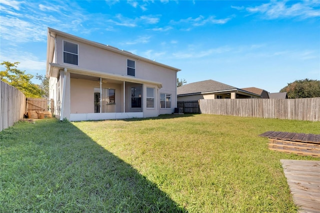 back of house with a lawn, a sunroom, and central air condition unit