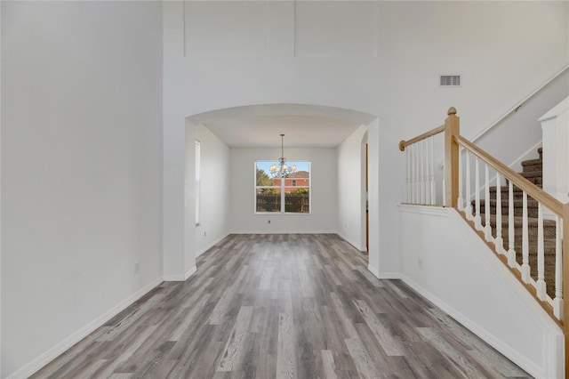 unfurnished living room featuring hardwood / wood-style flooring and an inviting chandelier