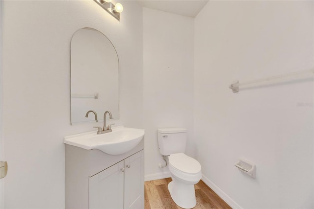 bathroom with vanity, toilet, and wood-type flooring