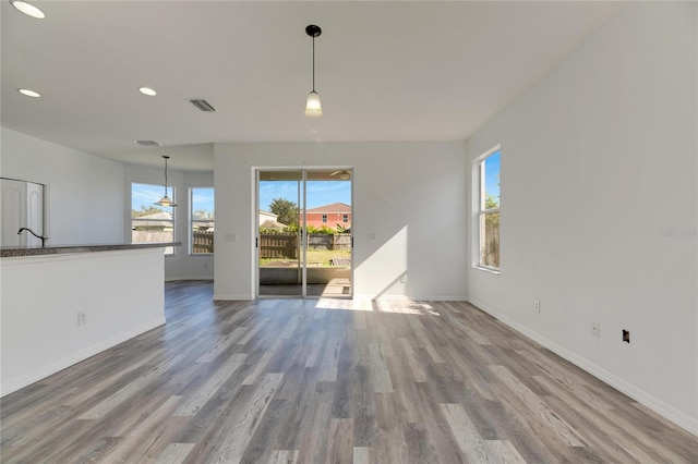 unfurnished living room with hardwood / wood-style flooring and sink