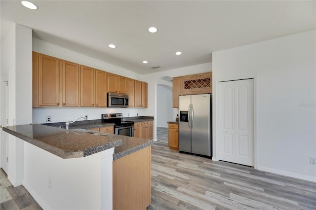 kitchen with sink, light wood-type flooring, a kitchen bar, kitchen peninsula, and stainless steel appliances