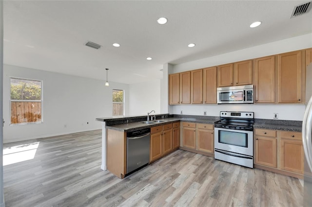 kitchen with kitchen peninsula, stainless steel appliances, sink, decorative light fixtures, and light hardwood / wood-style flooring