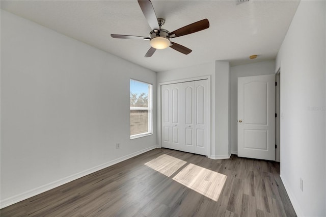 unfurnished bedroom featuring ceiling fan, a closet, and light wood-type flooring