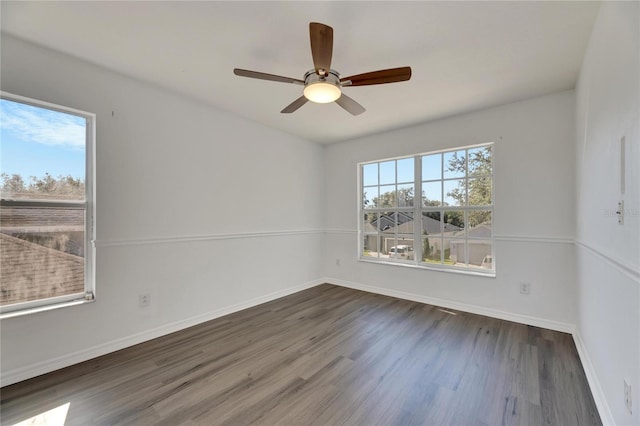 spare room with a wealth of natural light, dark hardwood / wood-style flooring, and ceiling fan