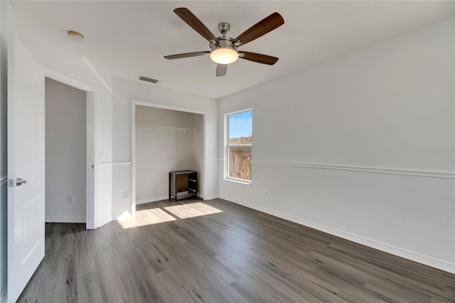 unfurnished bedroom with ceiling fan, dark hardwood / wood-style flooring, and a closet