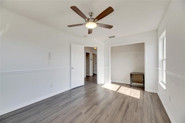 unfurnished bedroom with ceiling fan, a closet, and hardwood / wood-style flooring