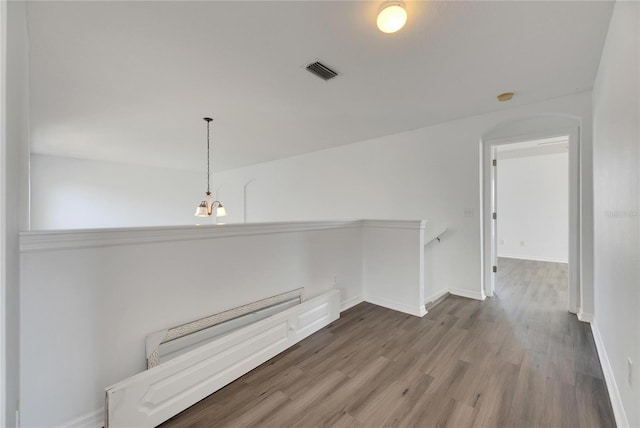 hall with wood-type flooring and a baseboard radiator