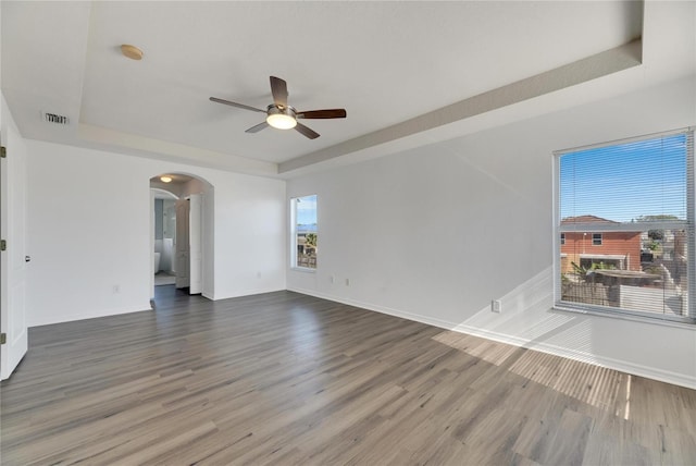 unfurnished room featuring hardwood / wood-style flooring, ceiling fan, and a tray ceiling