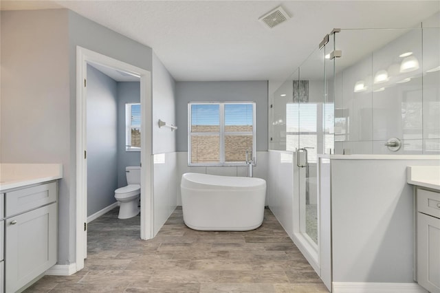 full bathroom with vanity, independent shower and bath, and toilet