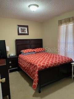 bedroom featuring carpet and a textured ceiling