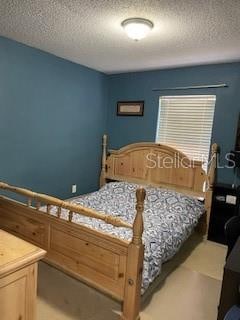 bedroom featuring carpet flooring and a textured ceiling