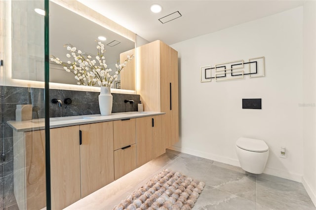 full bath featuring a sink, toilet, baseboards, and double vanity