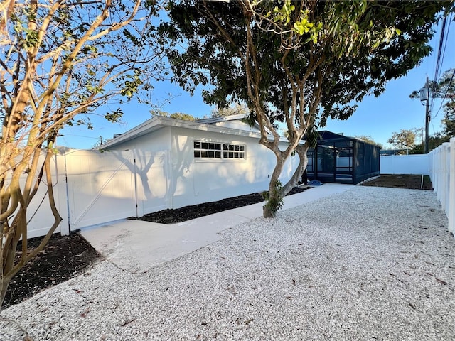 view of front of property with a lanai, driveway, and a fenced backyard