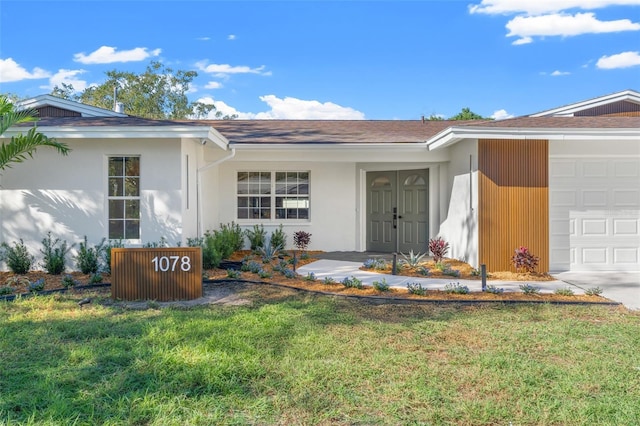 property entrance featuring a yard and a garage