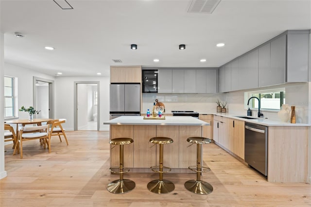 kitchen with light countertops, appliances with stainless steel finishes, modern cabinets, and a kitchen island