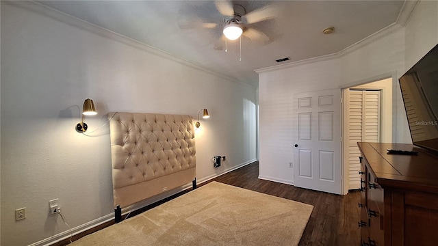 bedroom with ceiling fan, ornamental molding, dark wood-type flooring, and a closet