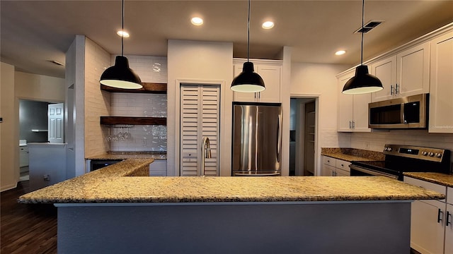 kitchen with white cabinetry, hanging light fixtures, light stone counters, dark hardwood / wood-style flooring, and appliances with stainless steel finishes