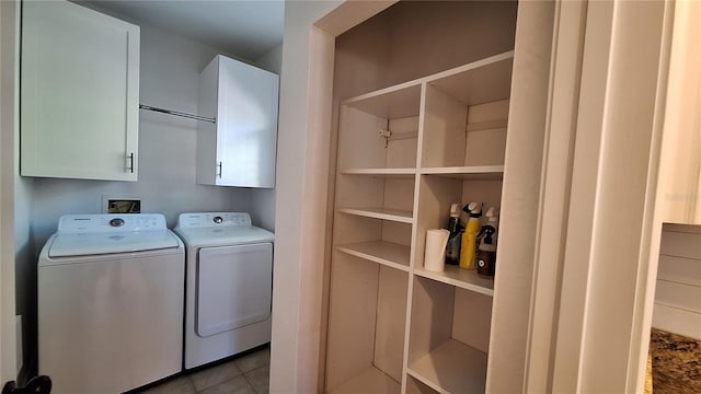 laundry area with cabinets, independent washer and dryer, and light tile patterned floors