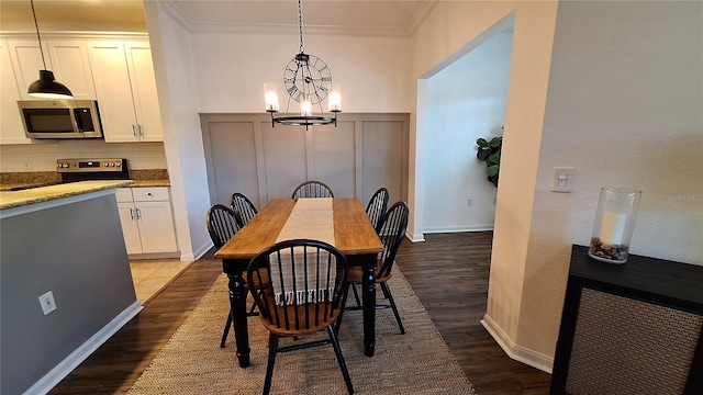 dining space with crown molding, hardwood / wood-style floors, and a notable chandelier