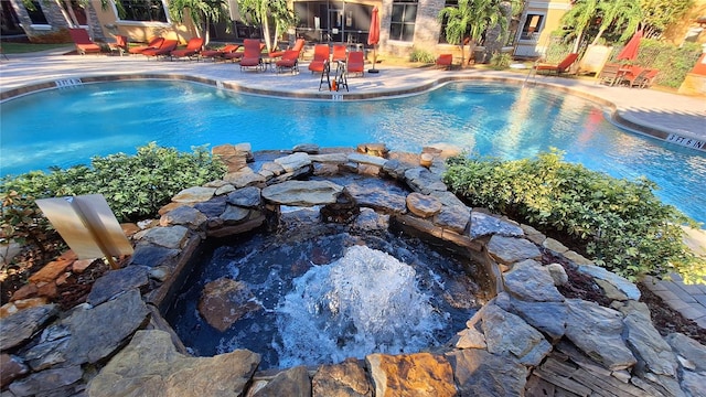 view of swimming pool featuring a patio and a hot tub