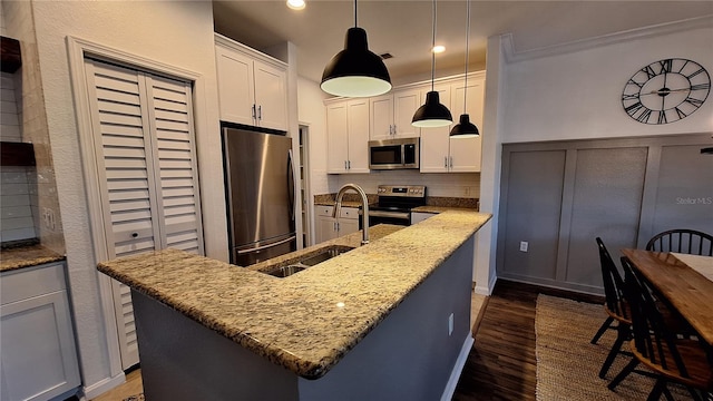 kitchen with white cabinetry, dark wood-type flooring, hanging light fixtures, tasteful backsplash, and appliances with stainless steel finishes