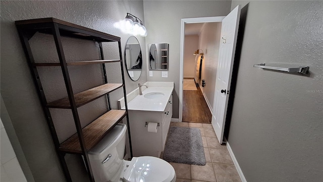 bathroom with tile patterned flooring, vanity, and toilet