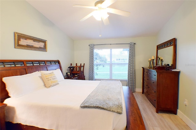 bedroom featuring ceiling fan, light hardwood / wood-style floors, and lofted ceiling