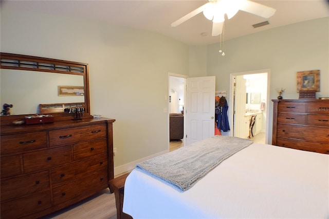 bedroom with ensuite bathroom, ceiling fan, lofted ceiling, and light wood-type flooring