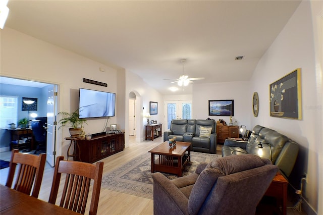 living room with ceiling fan, french doors, light hardwood / wood-style floors, and lofted ceiling