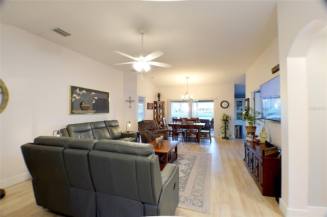 living room featuring lofted ceiling, light hardwood / wood-style floors, and ceiling fan with notable chandelier