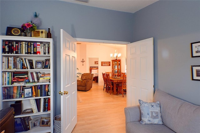 sitting room featuring light wood-type flooring and a notable chandelier