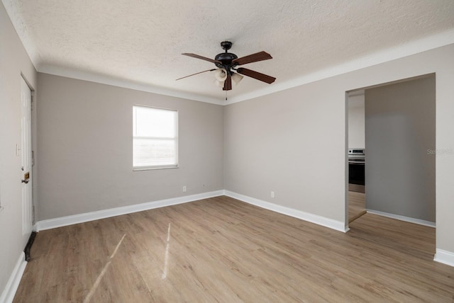 empty room with a textured ceiling, light hardwood / wood-style flooring, and ceiling fan