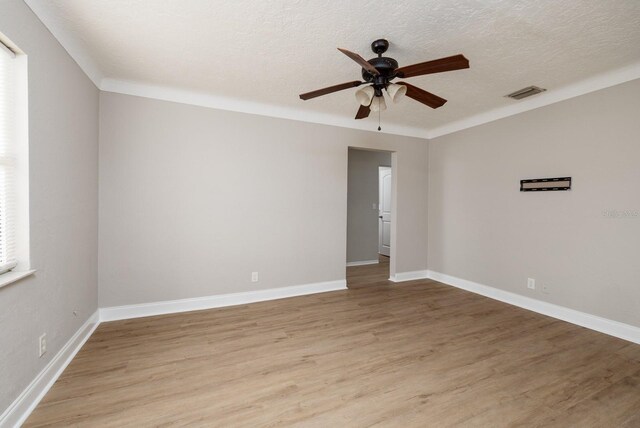 spare room with ceiling fan, a textured ceiling, and light wood-type flooring