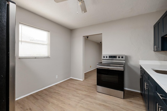 kitchen with ceiling fan, stainless steel electric range oven, and light hardwood / wood-style floors