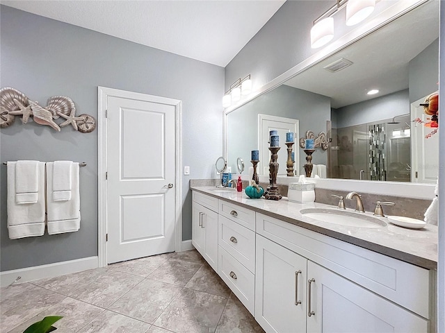 bathroom with tile patterned floors, vanity, and walk in shower