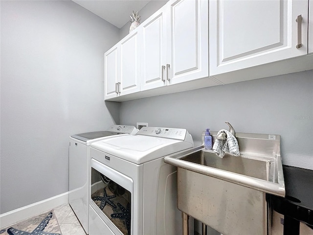 laundry area featuring washer and dryer, light tile patterned floors, cabinets, and sink