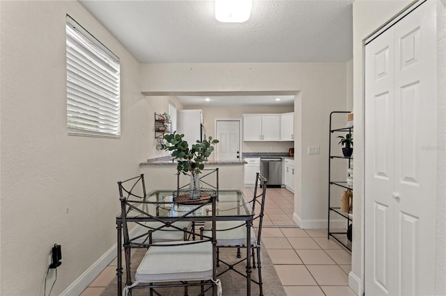 tiled dining space featuring a textured ceiling