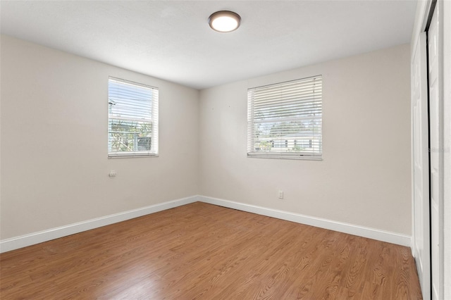 unfurnished room with plenty of natural light and wood-type flooring