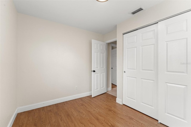 unfurnished bedroom featuring light hardwood / wood-style flooring and a closet