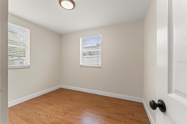 empty room with light hardwood / wood-style floors and a healthy amount of sunlight