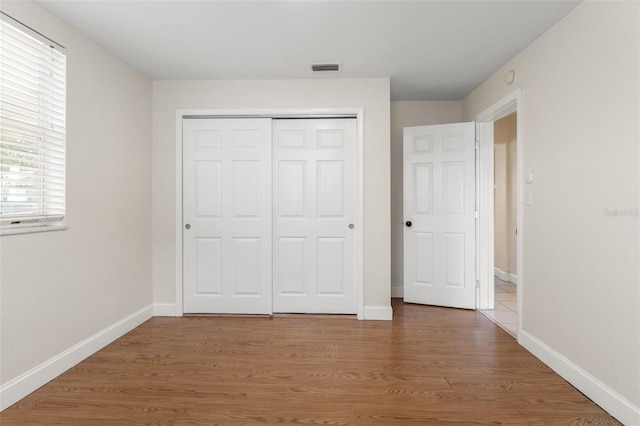 unfurnished bedroom featuring hardwood / wood-style flooring and a closet