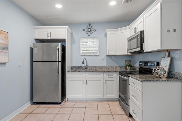 kitchen featuring sink, white cabinetry, stainless steel appliances, and dark stone counters