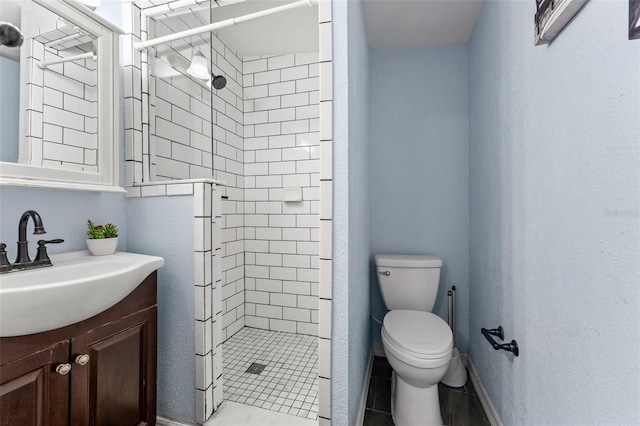 bathroom featuring tile patterned floors, vanity, toilet, and a shower with shower door