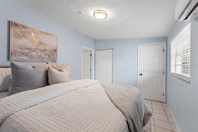 tiled bedroom featuring a wall mounted air conditioner