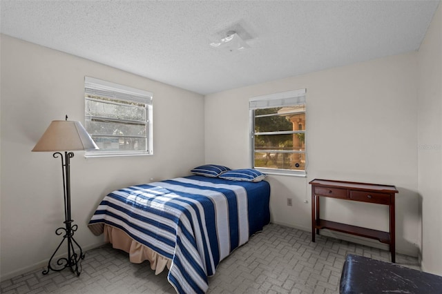 bedroom with multiple windows and a textured ceiling