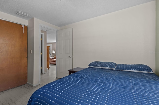 carpeted bedroom featuring a textured ceiling and a closet