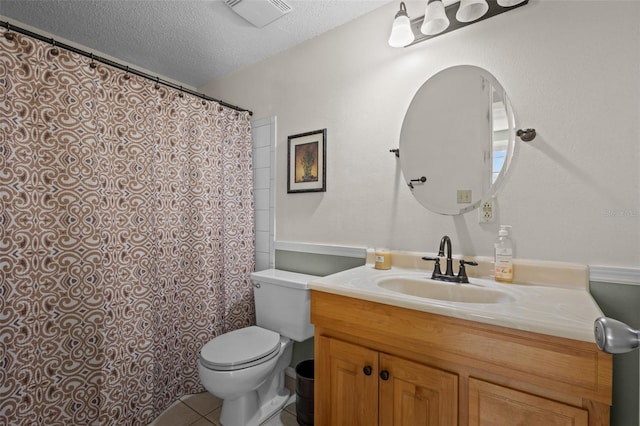 bathroom featuring tile patterned flooring, vanity, toilet, and a textured ceiling