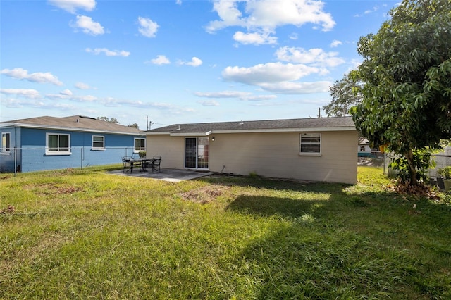 back of house featuring a patio area and a lawn